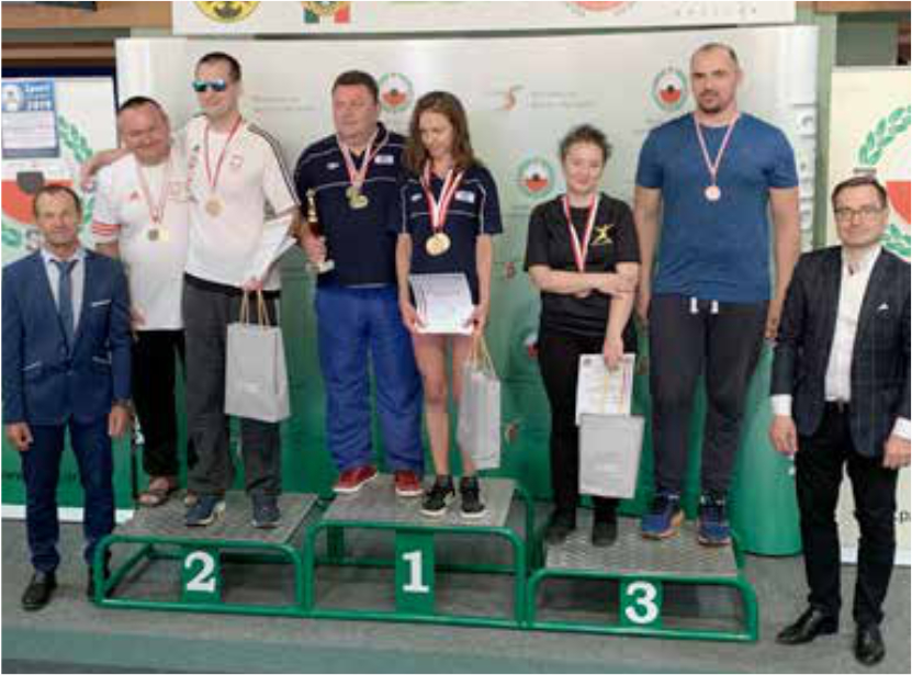 Osoby stojące na podium z medalami i dyplomami