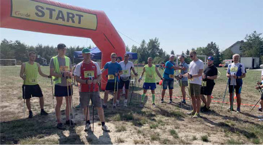 Grupa osób z kijkami do nordic walking szykująca się do marszu