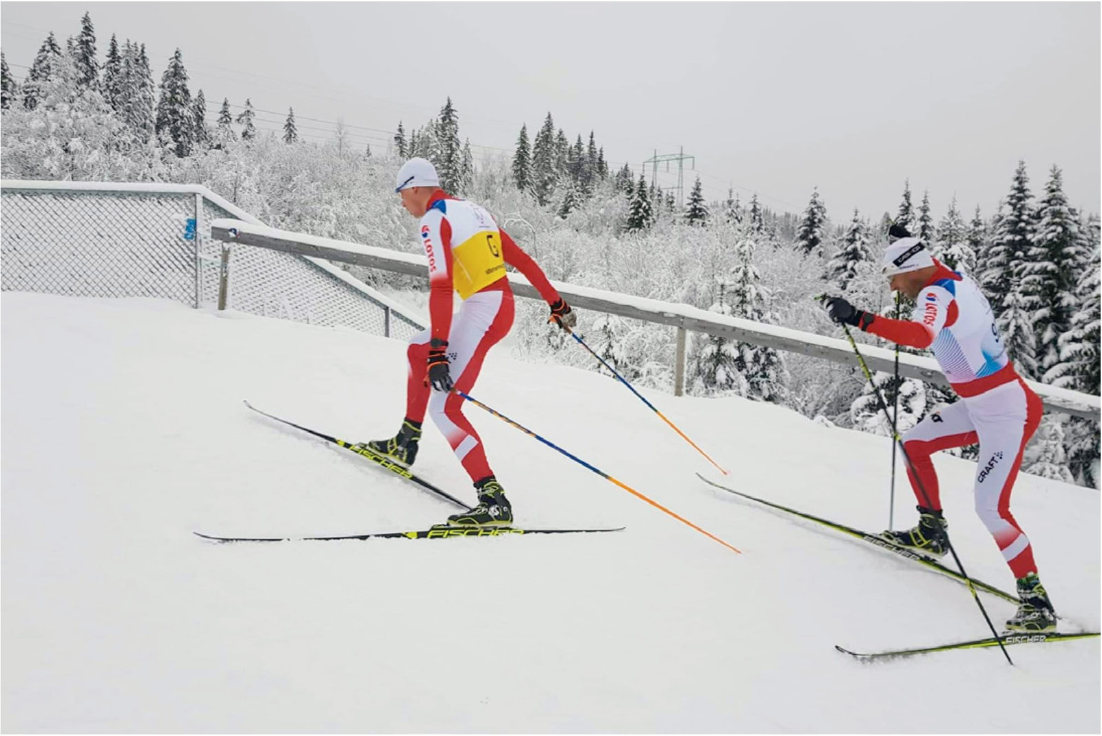 Osoby na nartach biegnące pod górę
