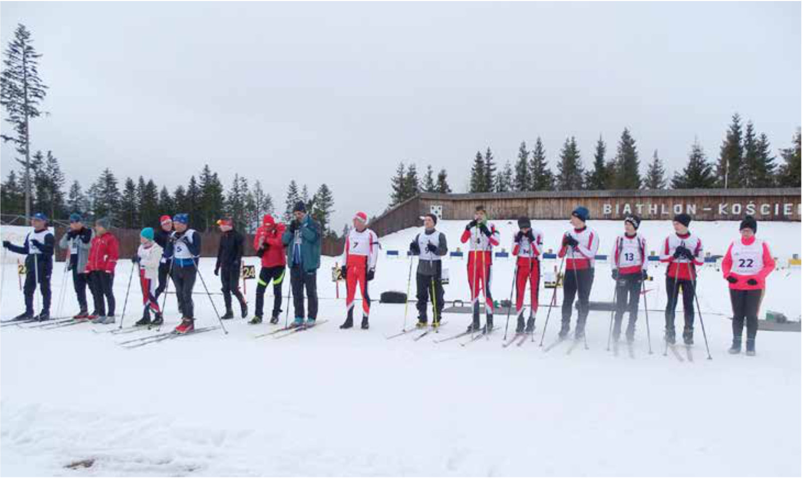 Grupa osób stojących na nartach w jednej lini