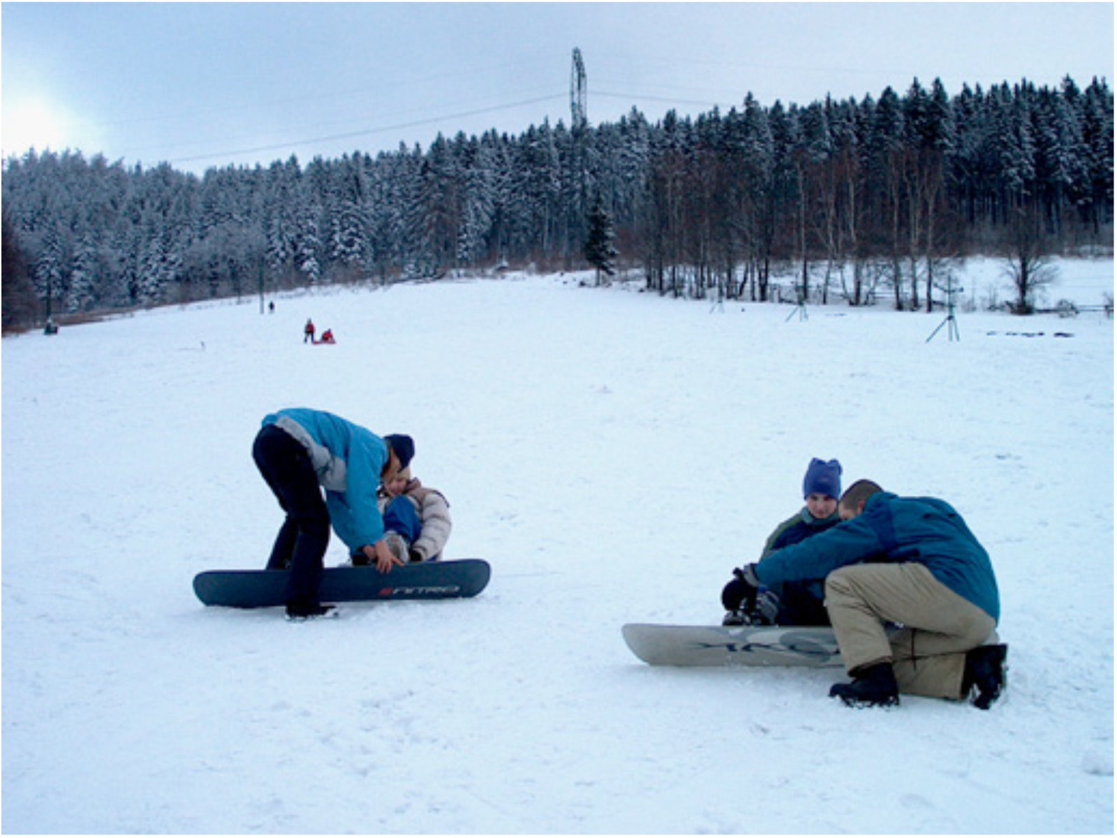 Osoby na deskach snowbordowych