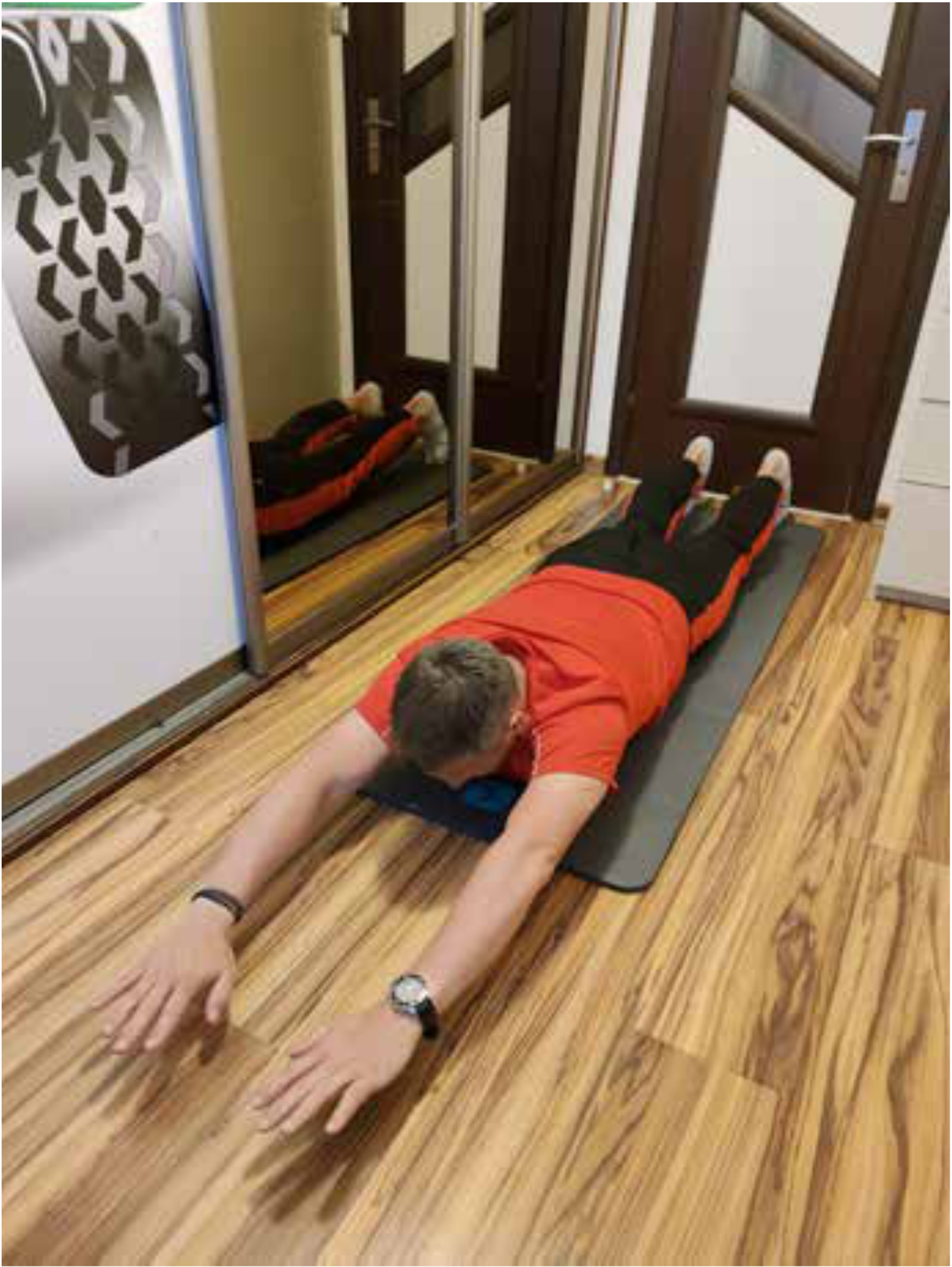 Mężczyzna leżący na macie z rękami w g&oacute;rze