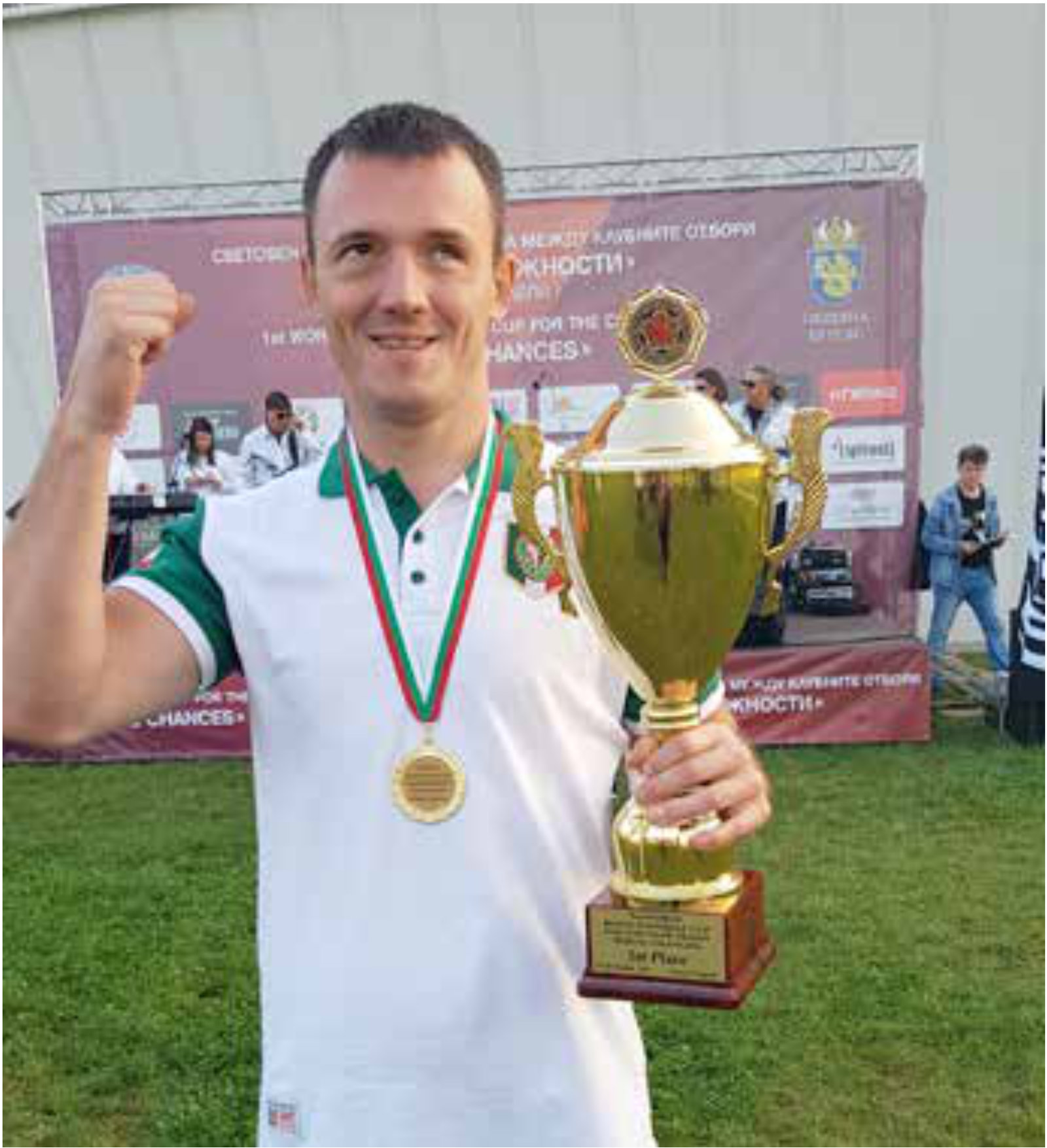Mężczyzna z medalem na szyi i pucharem