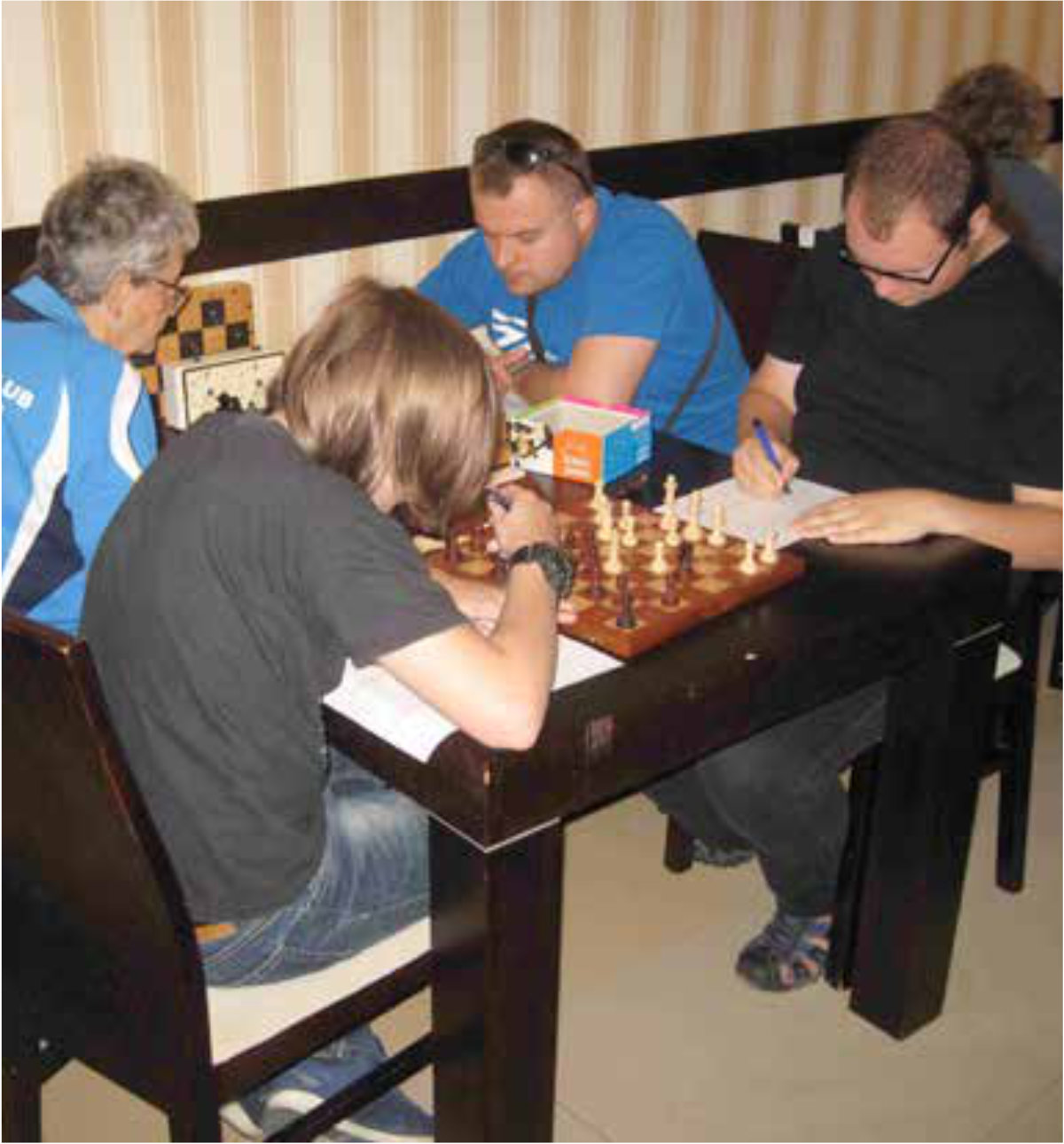 Osoby grające w szachy przy stoliku