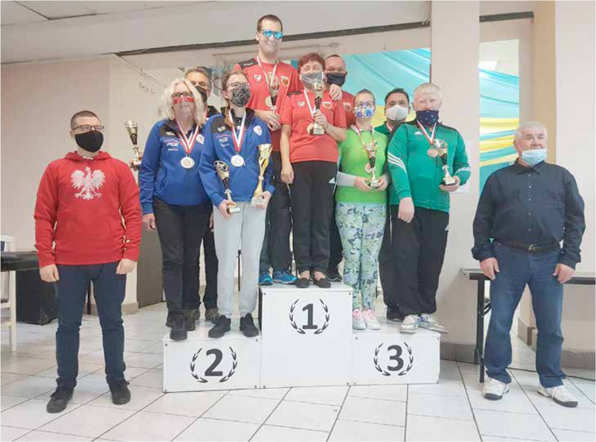 Grupa osób na podium z medalami na szyi