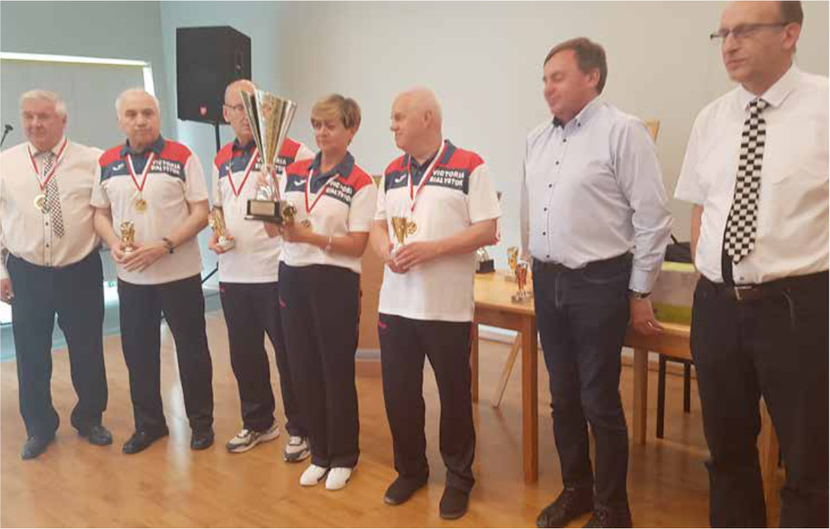 Grupa osób z medalami i pucharem