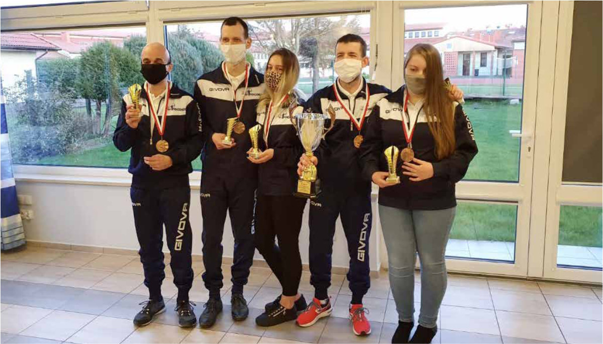 Czteroosoobwa druzyna z medalami i pucharem pozuje do zdjęcia