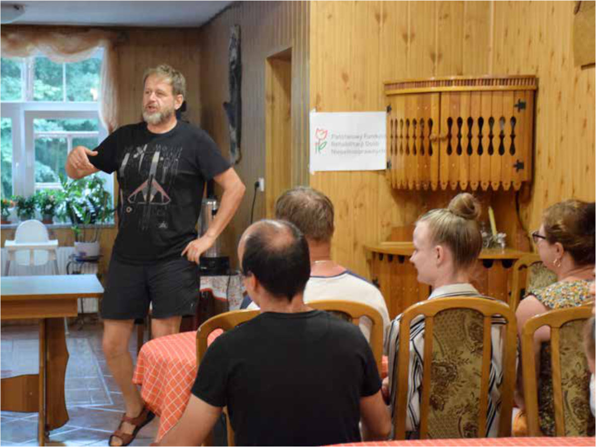 Szkoleniowiec stoi i opowiada, prowadzi wykład