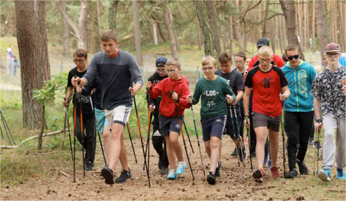 Grupa uczestników zawodów w nordic walkingu.