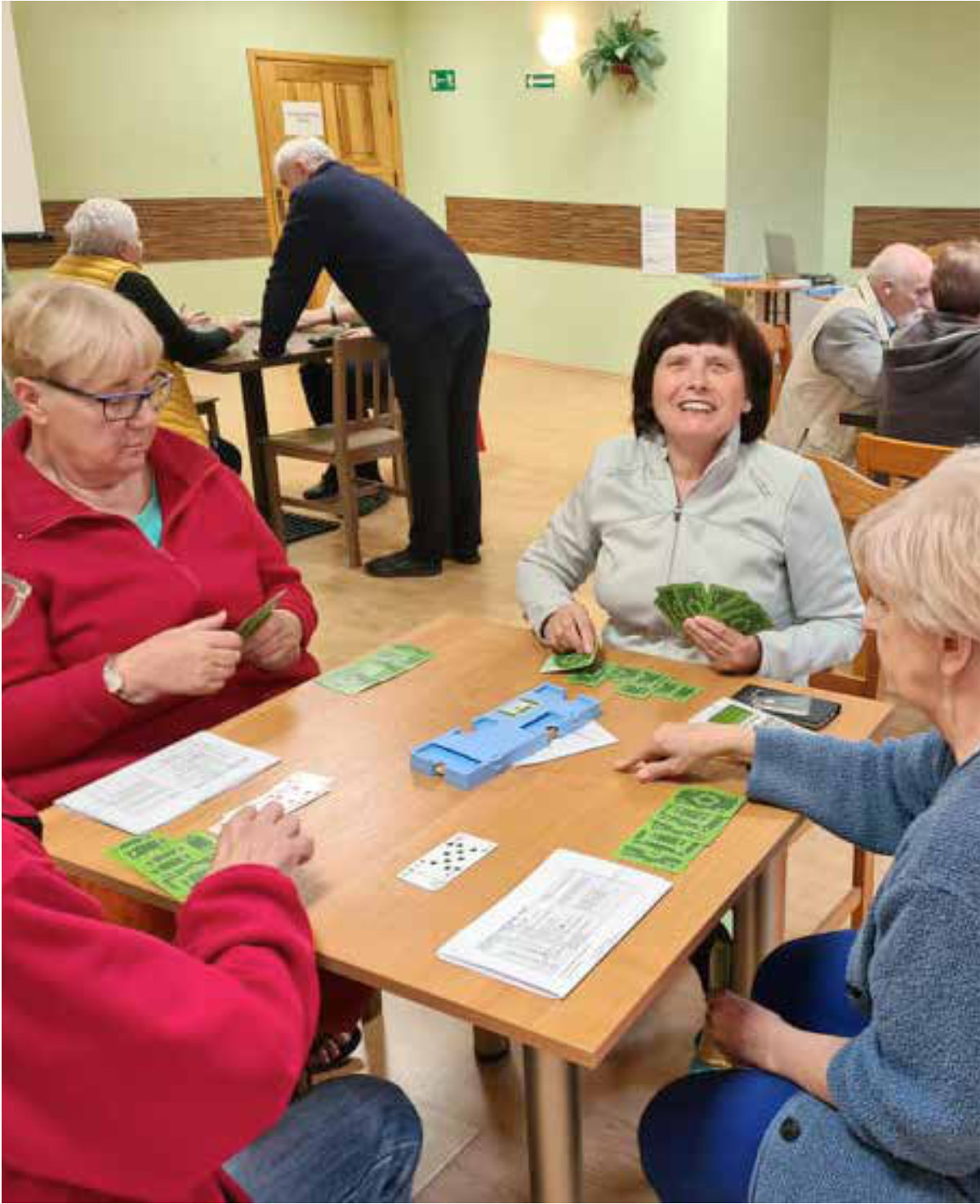 Zawodnicy brydża siedzą przy swoich rozgrywkach