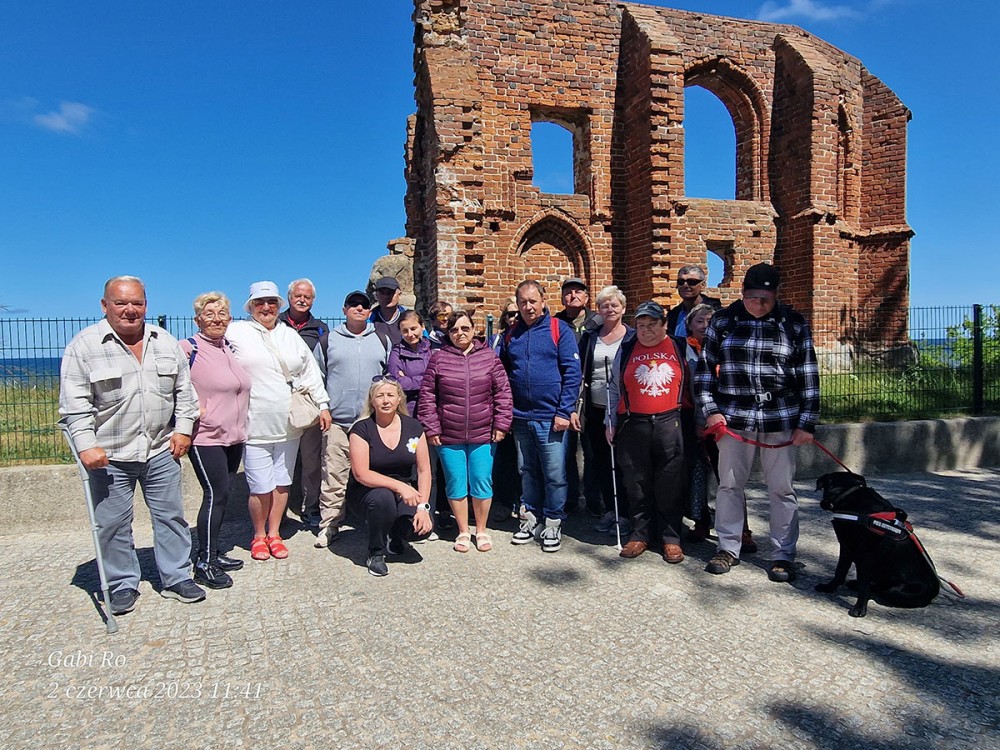 grupa osób na tle ruin