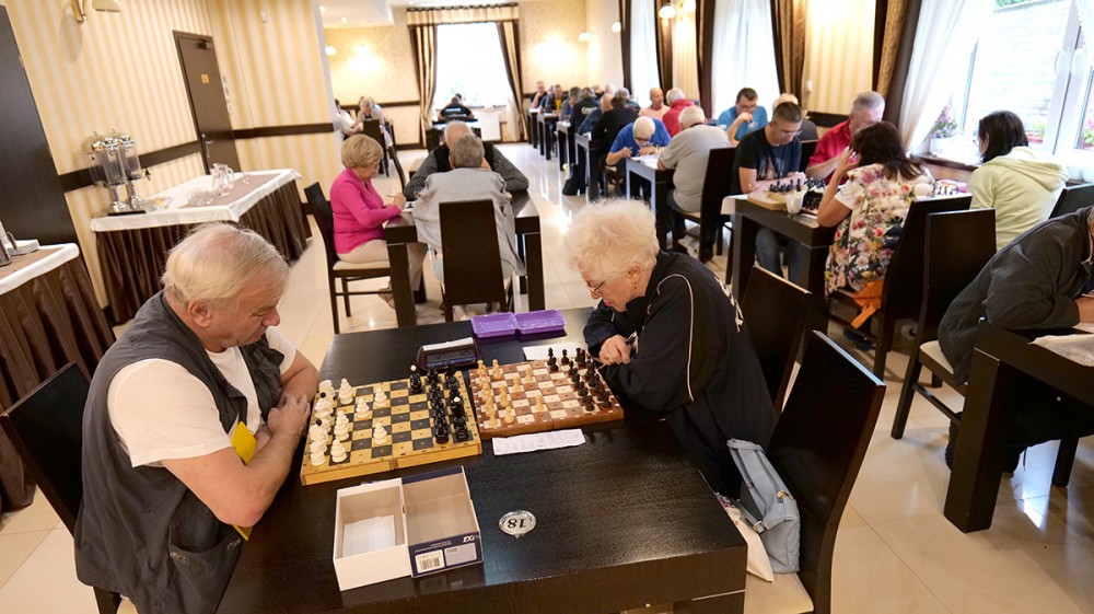grupa osób gra w szachy