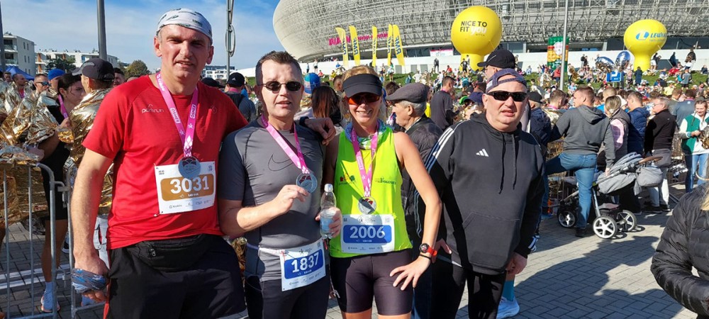grupa osób z medalami na tle stadionu