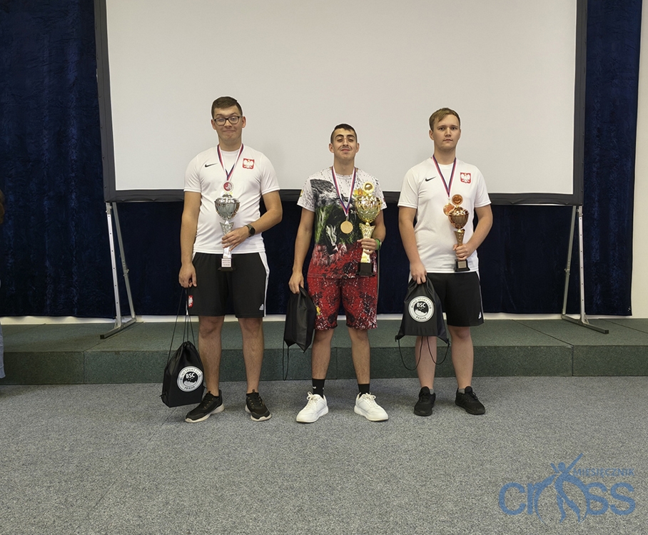 trzech mężczyzn z medalami i pucharami