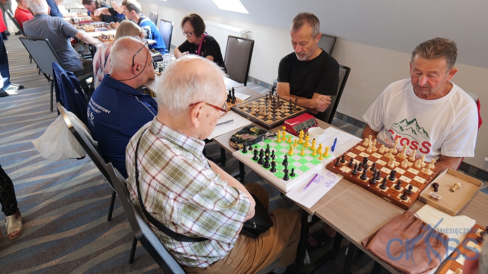 grupa os&oacute;b przy szachownicach