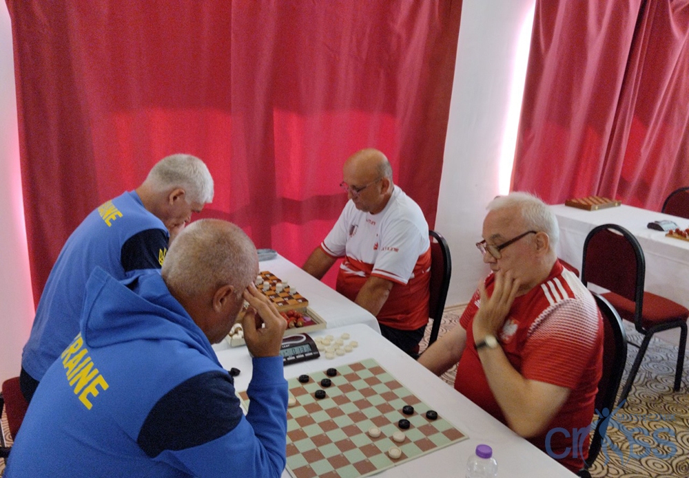 grupa os&oacute;b grająca w warcaby