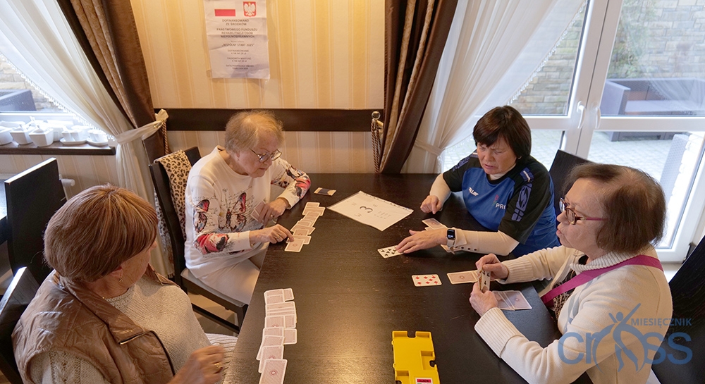 grupa os&oacute;b w trakcie gry w brydza