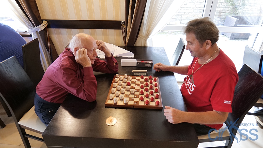 dw&oacute;ch mężczyzn w trakcie gry w warcaby