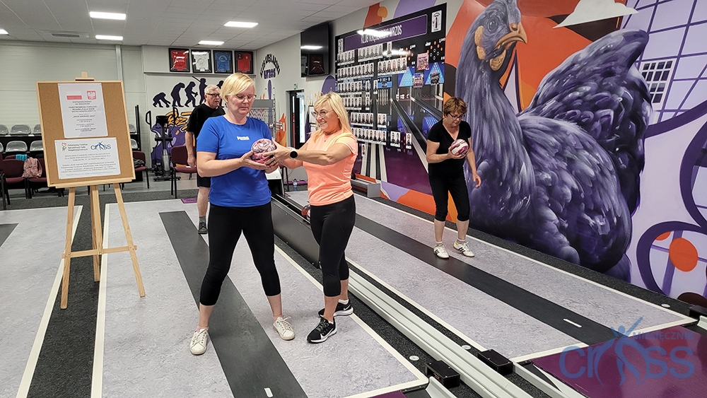 dwie kobiety, jedna z nich podaje kulę drugiej