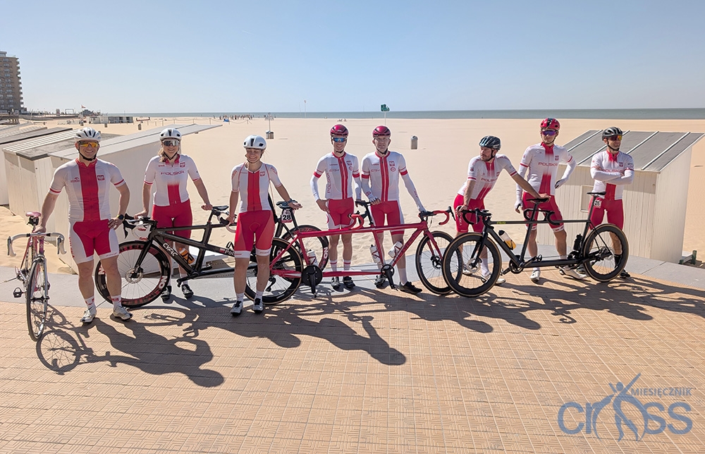 grupa os&oacute;b z tandemami na tle plaży