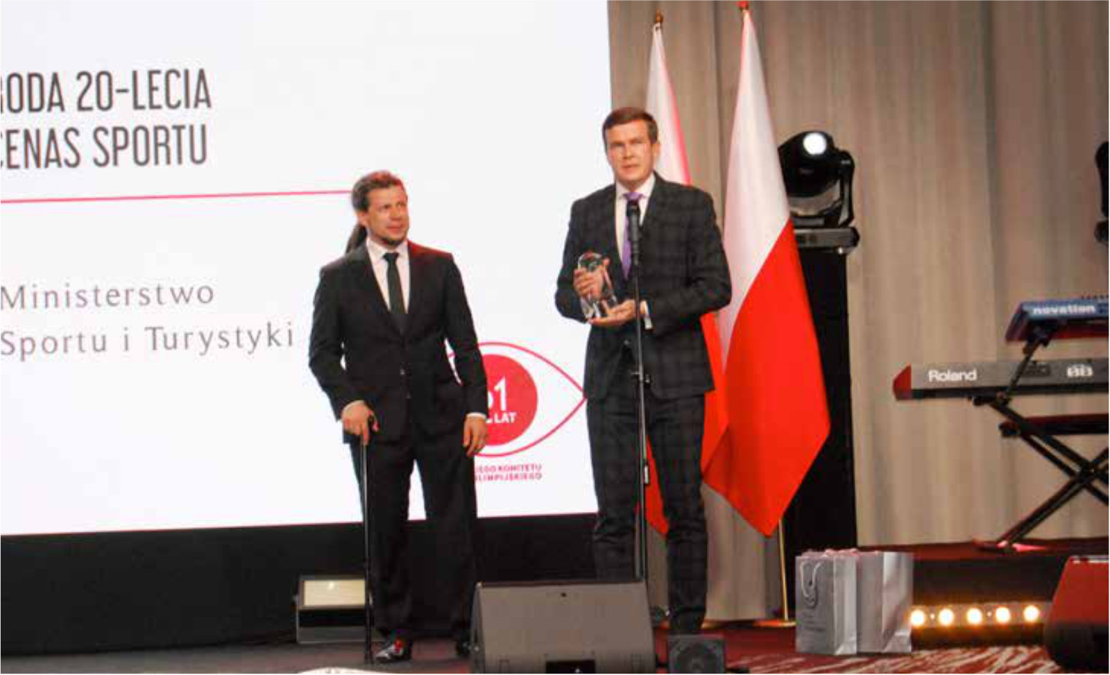Dwaj mężczyźni stojący nta tle baneru