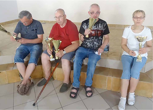 Trzej mężczyźni oraz jedna kobieta z pucharami