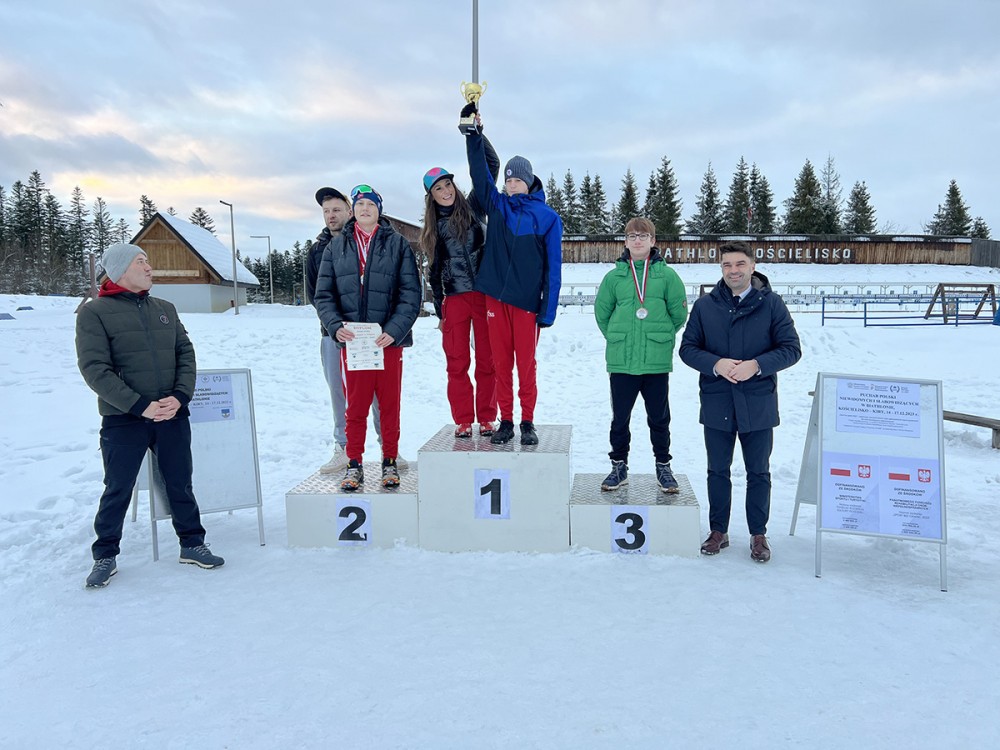 grupa osób z pucharami i medalami