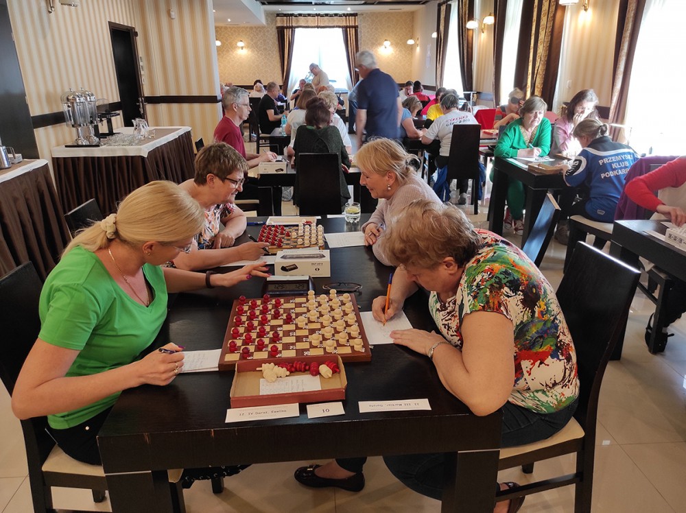 grupa osób przy warcabownicach