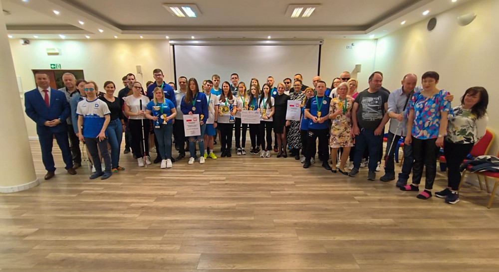 grupa osób na sali z pucharami i medalami