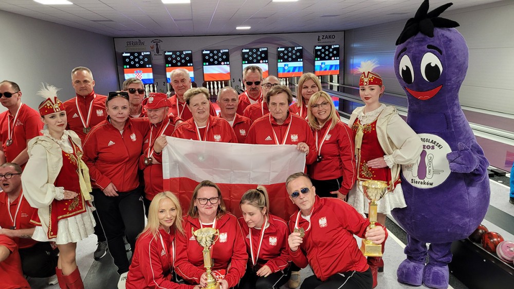 grupa osób z pucharami i medalami