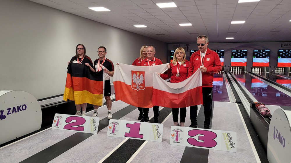 grupa osób z flagami na kręgielni