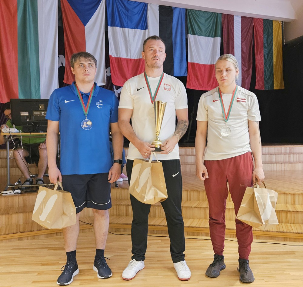 grupa osób z pucharami i medalami