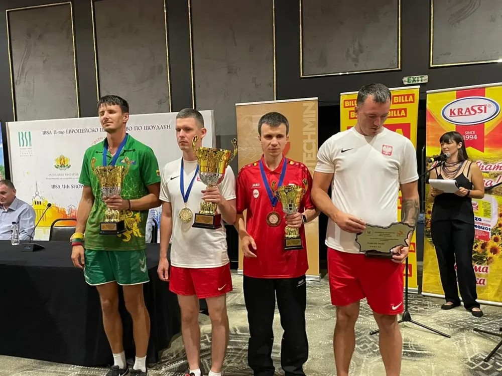 grupa osób z pucharami i medalami