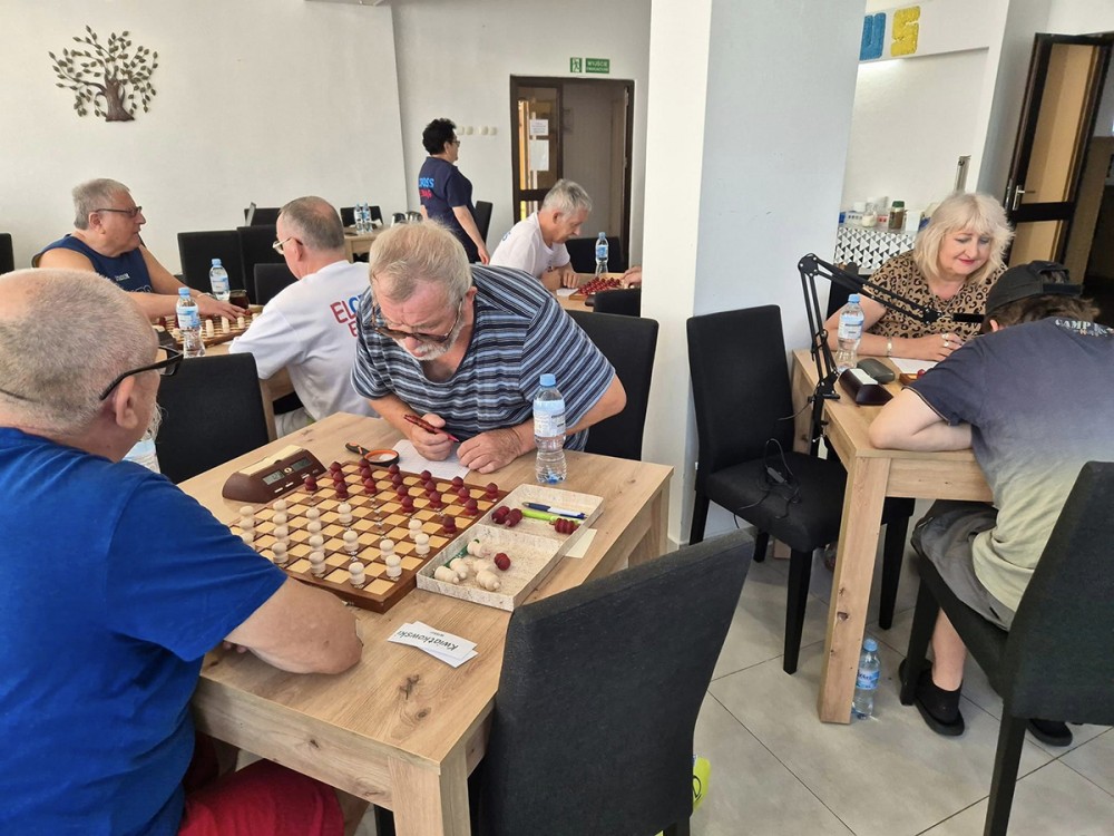 grupa osób gra w warcaby