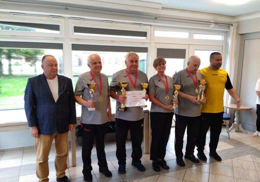 grupa osób z pucharami i medalami