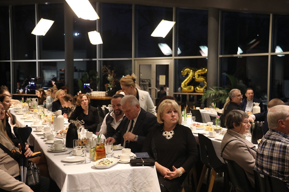 grupa osób siedzi przy stołach