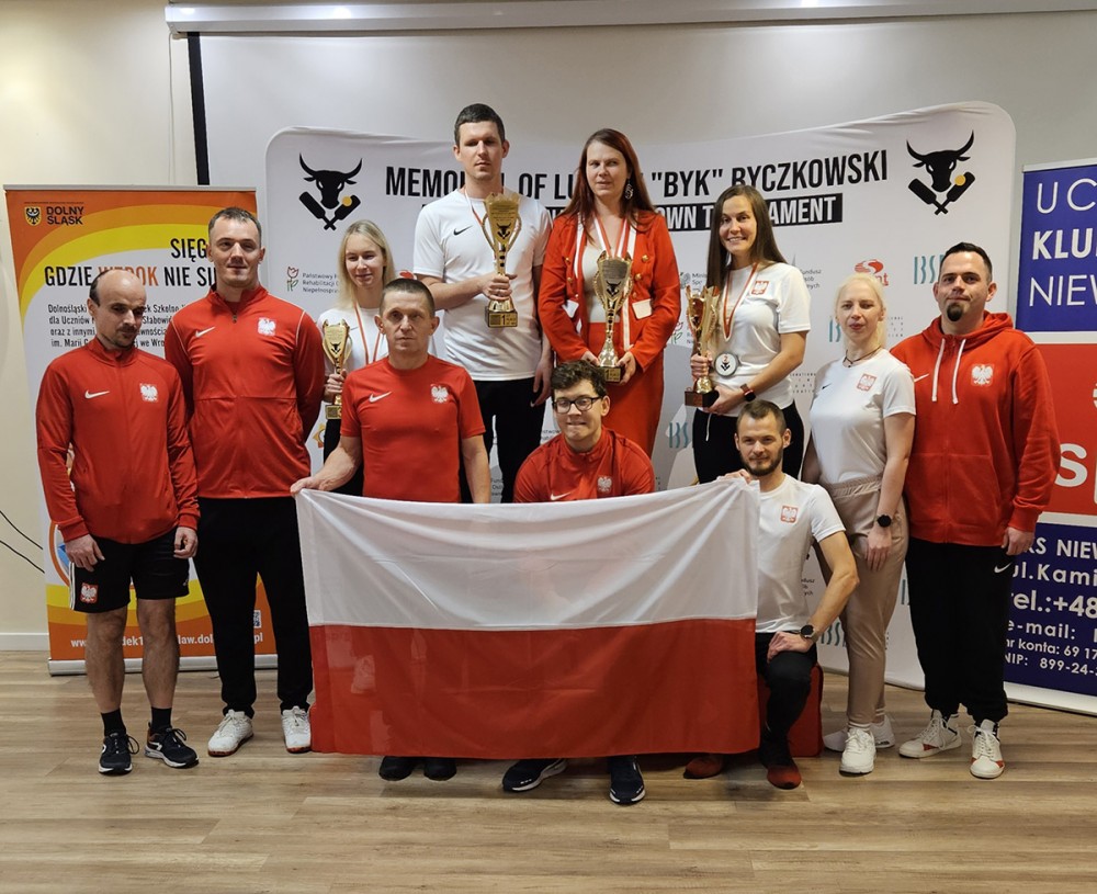 grupa osób z flagą przed sobą