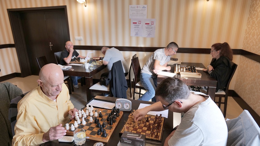 grupa osób gra w szachy