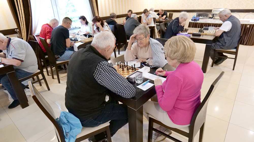grupa osób gra w szachy