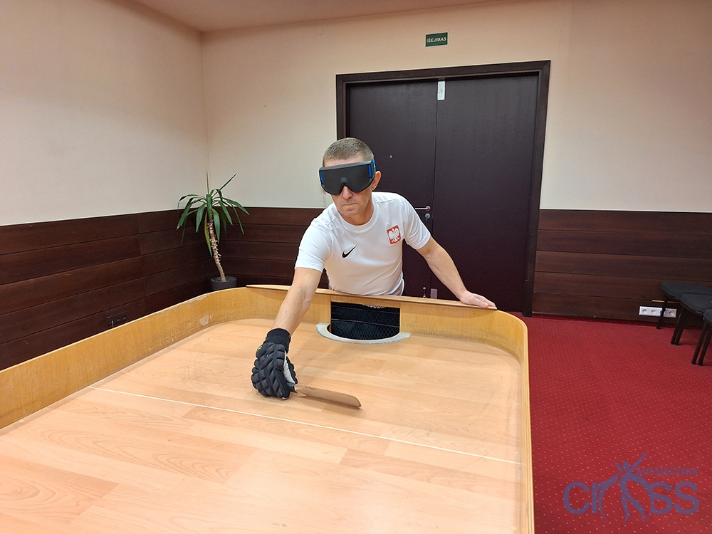 osoba przy stole z rakietką w ręku
