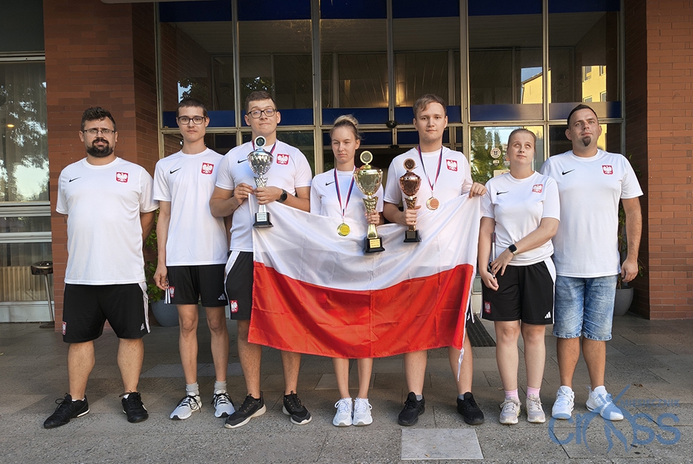 grupa osób z pucharami i medalami w reprezentacyjnych strojach