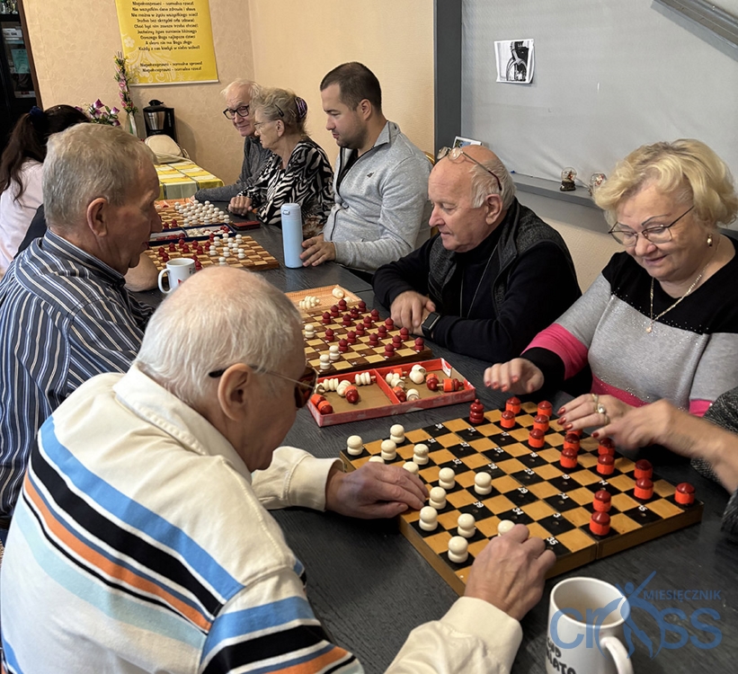 grupa osób na sali gra w warcaby