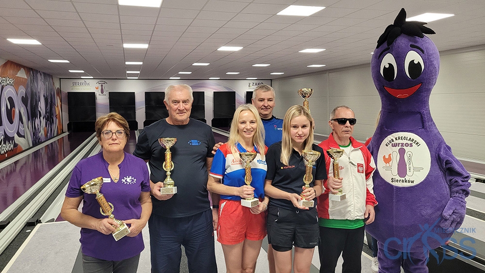 grupa osób na podium z pucharami