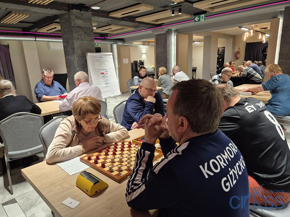 grupa osób w trkacie gry w warcaby