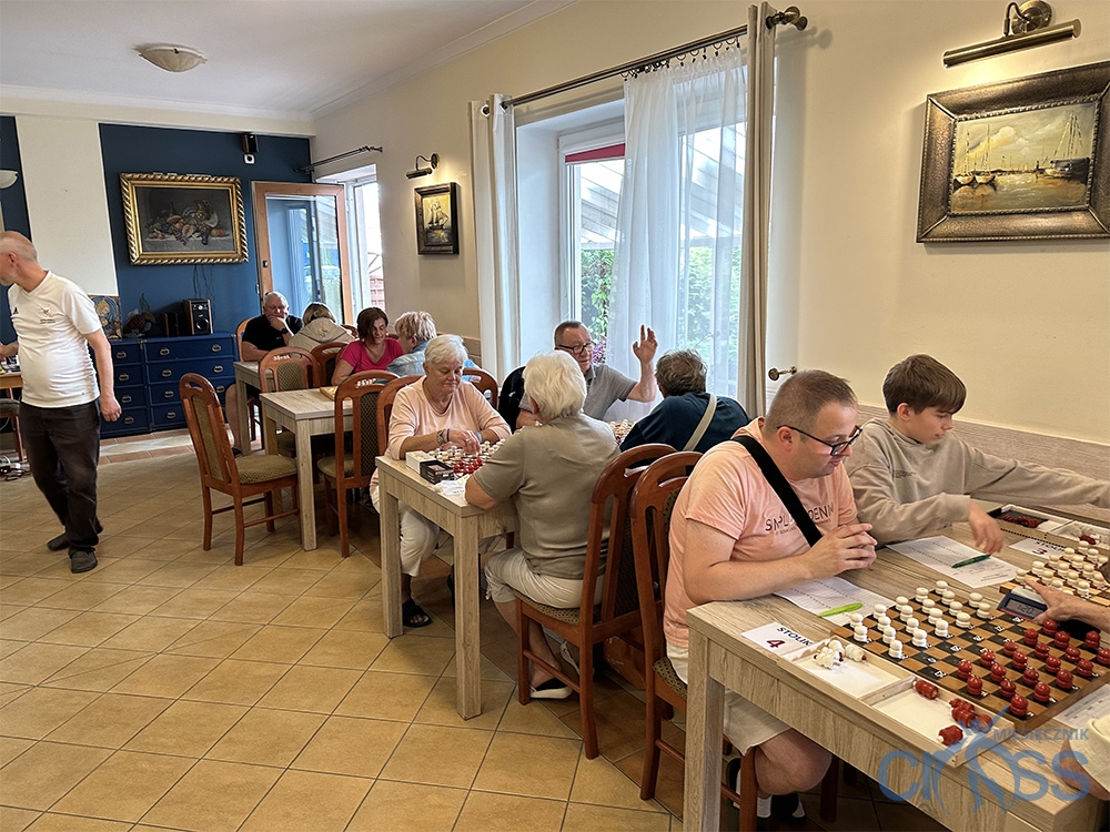 grupa osób gra w warcaby
