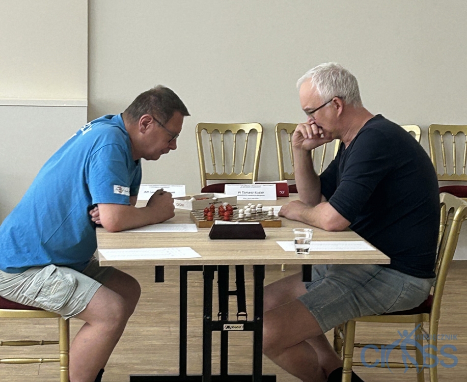 dwóch mężczyzn przy stole gra w warcaby