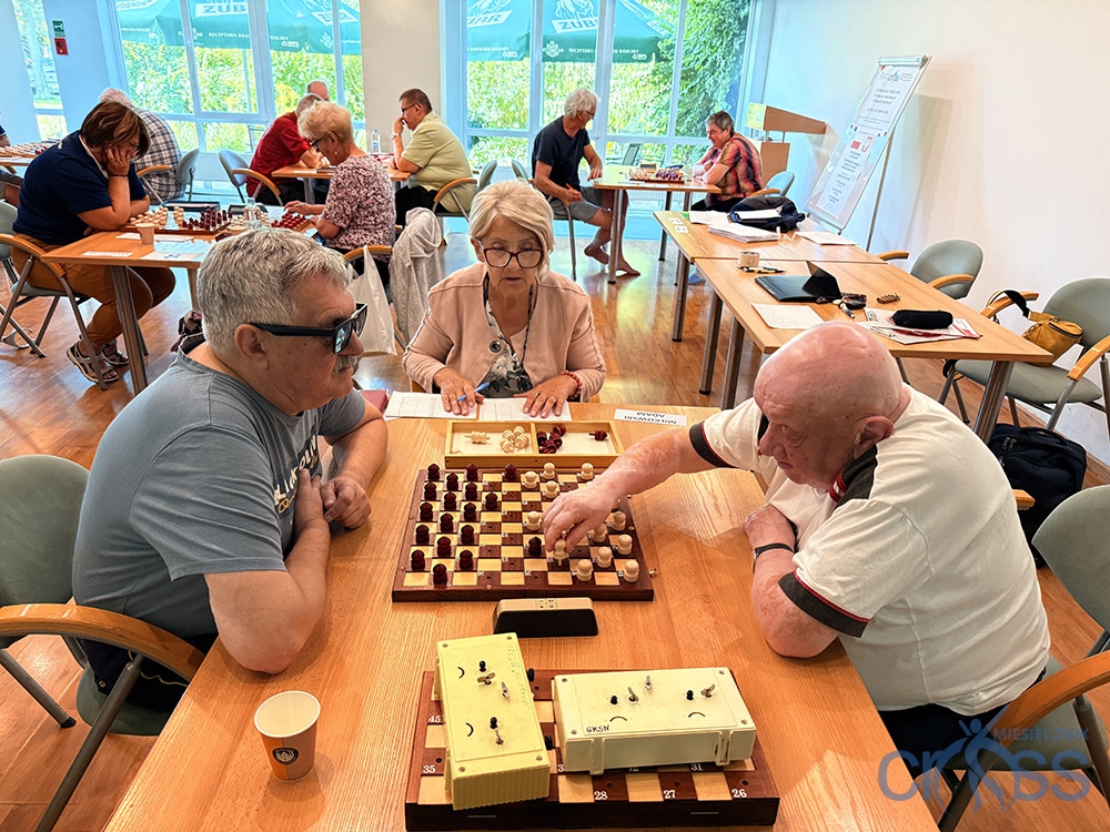 grupa osób gra w warcaby