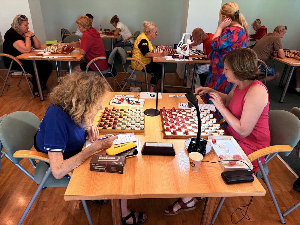 grupa osób w trakcie gry w warcaby